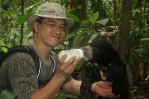 Siew Te Wong and orphaned bear cub borneo by chris morgan